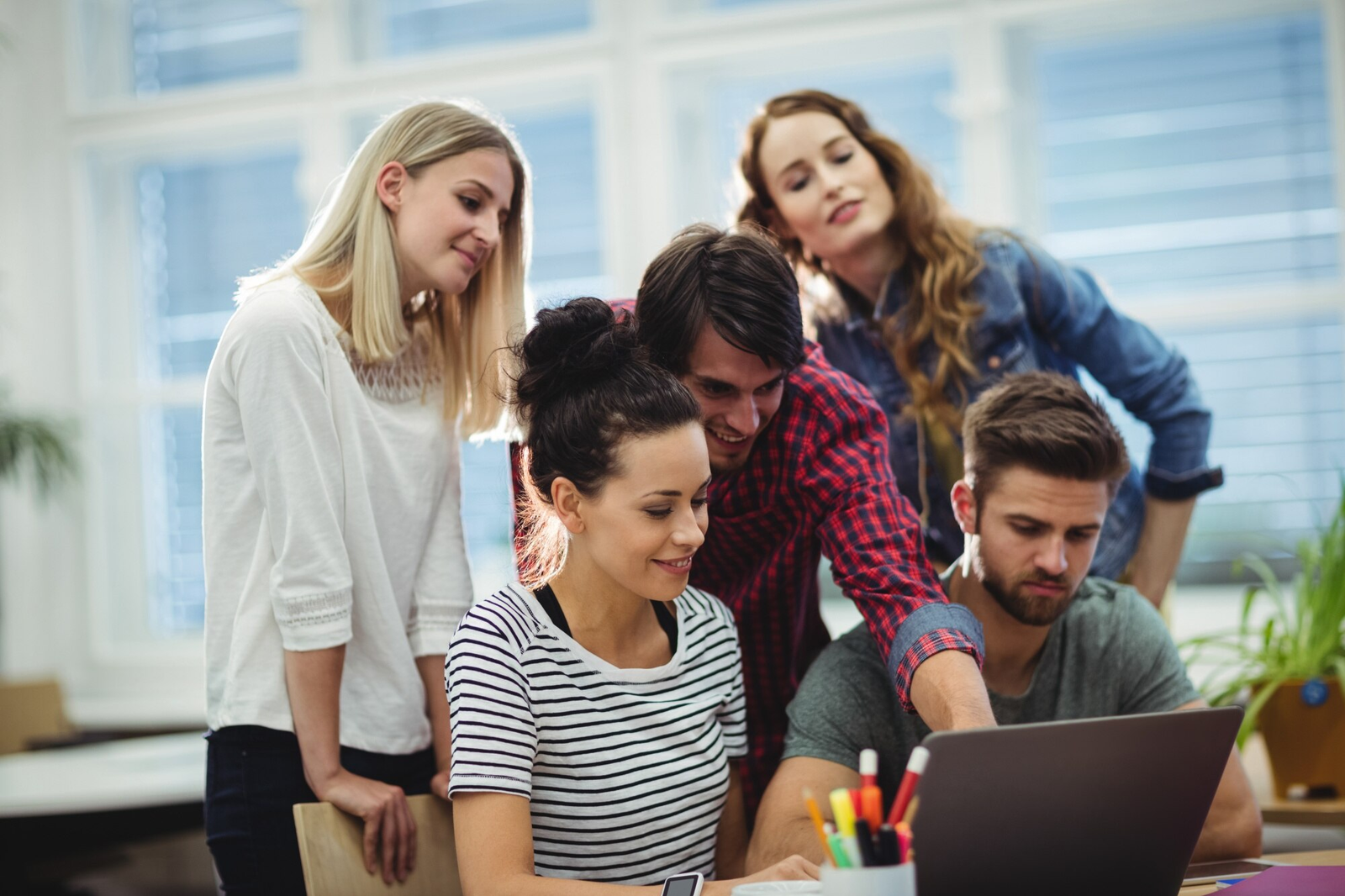 Team arbeitet gemeinsam an einem Laptop